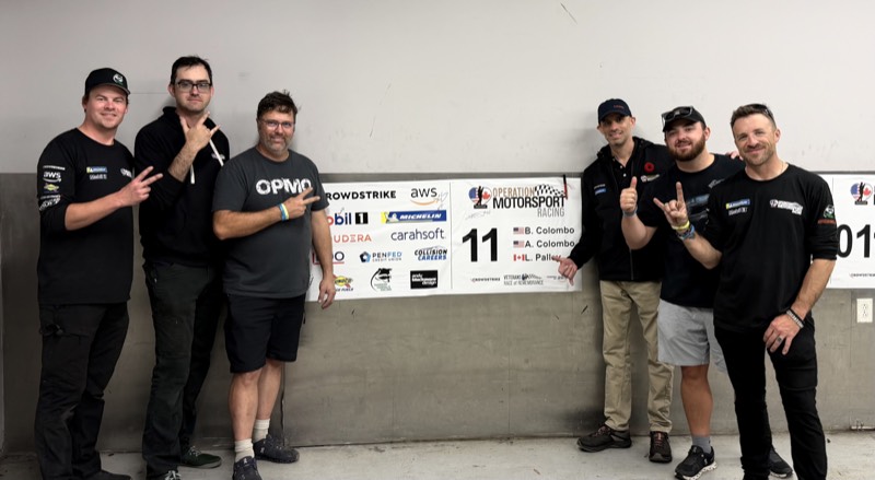 Team photo with Operation Motorsport Racing banner
